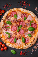 Delicious fresh oven baked pizza with salami, meat, cheese, tomatoes