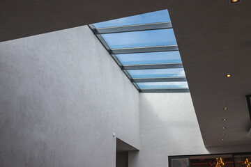 The second light in modern interior, a window on the ceiling with a blue sky behind it.