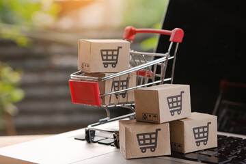 Shopping online. cardboard box with a shopping cart logo in a trolley on laptop keyboard. Shopping service on The online web. offers home delivery