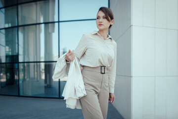 Fototapeta premium Outdoor shot of caucasian business woman, going somewhere in city centre, walking on street, going to work.