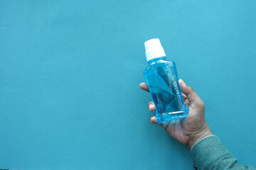  hand hold a mouthwash liquid container 