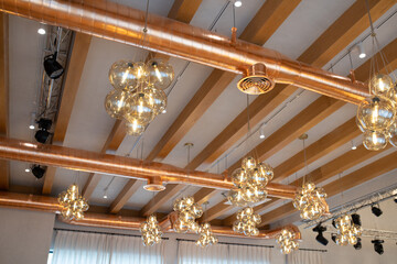 Ventilation system copper color, open type. Ceiling in a modern loft style with wooden beams,...