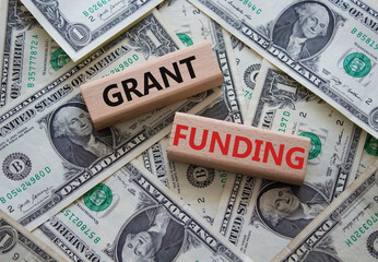Grant funding symbol. Wooden blocks with words Grant funding. Beautiful dollar background. Business...
