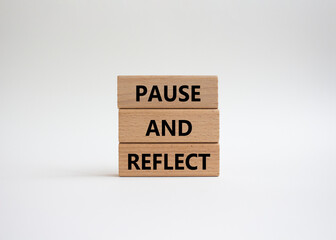 Pause and Reflect symbol. Concept words Pause and Reflect on wooden blocks. Beautiful white background. Business and Pause and Reflect concept. Copy space.