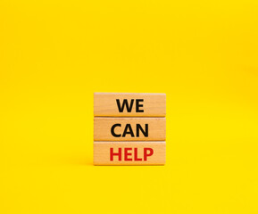 We can help symbol. Wooden blocks with words We can help. Beautiful yellow background. Business and We can help concept. Copy space.