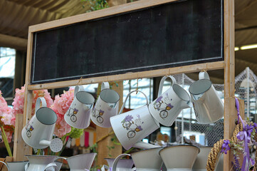 Cans and jugs displayed in the gardening shop under the sign for the inscription