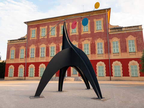 Matisse museum (Musee Matisse de Nice) located in Jardin des Ar&egrave;nes de Cimiez. In front of the museum a sculpture by Alexander Calder - Stabile-mobile, 1970.  Nice, France - June 7, 2023.