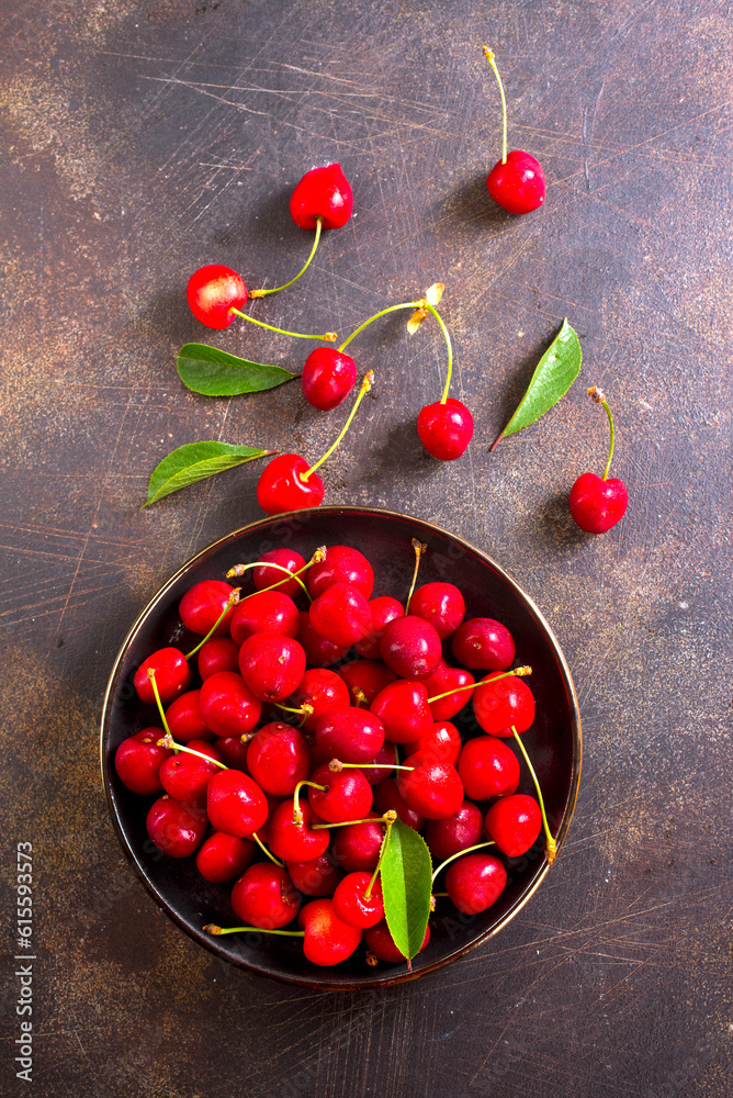 Wall mural large bowl of bright red cherries on dark background