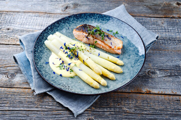 Traditionell gedämpfter weißer Spargel mit Lachs Filet und Sauce Hollandaise serviert als...