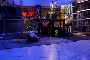 Hackers abandoned warehouse with graffiti and neon light at night. Cybercriminals computers and...