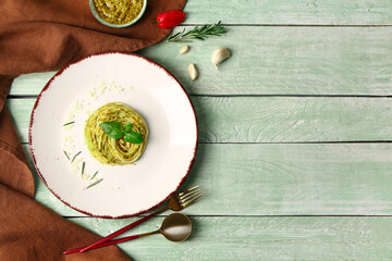 Plate with tasty pesto pasta on color wooden background