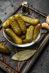 Bowl with tasty fermented cucumbers on dark grunge background