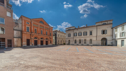 Alba, Langhe, Piedmont, Italy - August 16, 2022: cityscape of Vittorio Veneto cobblestone square with building of the Teatro Sociale (social theater) and ancient buildings