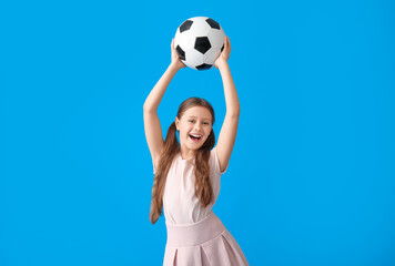 Happy little girl with soccer ball on blue background