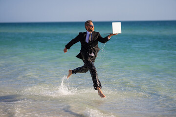 Fast business. Freelancer run outdoor. Businessman in suit with laptop running in sea water. Travel...