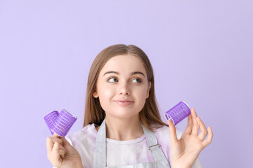 Female hairdresser with curlers on lilac background, closeup