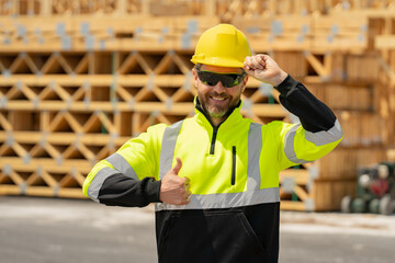 Worker in building uniform on buildings construction background. Builder at the construction site. Man worker with helmet on construction site. American bilder in hardhat.