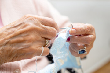 Elderly woman crocheting in a handicraft course as a hobby or occupational therapy at nursing home. High quality photo
