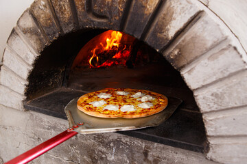 Pizza baking in heat wood oven