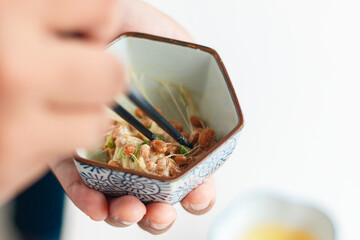 Natto (fermented soybeans) drawing sticky strings on chopsticks,Traditional Japanese food