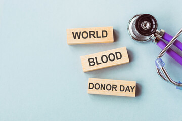 Wooden blocks with words World blood donor day and stethoscope. Medical concept.