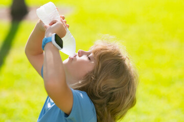 Portrait of little child with bottle of fresh water. Thirsty kid. Refreshing. Water balance. Close up portrait of kid drinking water in park. Portrait of child drinking waters.