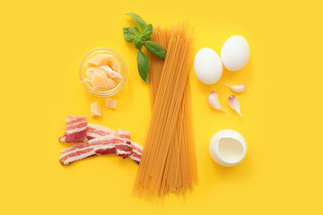 Ingredients for tasty pasta carbonara on yellow background