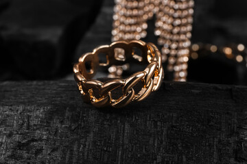 Beautiful ring and earrings on black charcoal, closeup