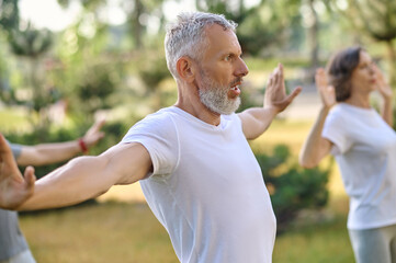 Mature group of people workout and practice tai chi.