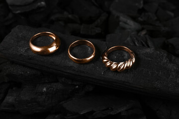 Beautiful rings on black charcoal, closeup