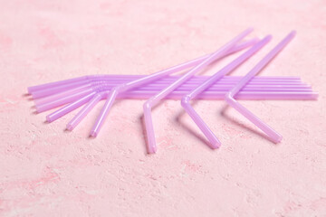 Many purple straws on grunge pink background