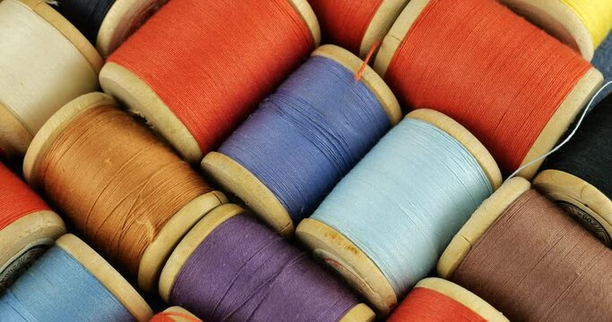 Vintage wooden spools with cotton threads in different colors.