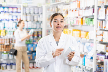 Positive female pharmacist offers various body care medicines