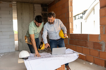 Two accomplished professionals, a male architect and a construction manager, collaborate on-site,...