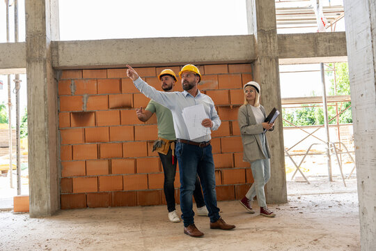 Architects and the construction manager inspect the construction site, collaborating and ensuring precision, as they work together to bring their architectural vision to life.