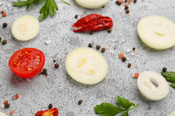 Fresh onion slices, tomato and spices on grey background, closeup