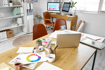 Graphic designer's workplace with laptop in office