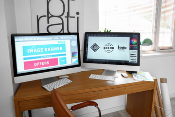Graphic designer's workplace with computer monitors in office