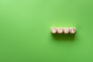 There is wood cube with the word BNPL. It is an abbreviation for Buy Now, Pay Later as eye-catching...