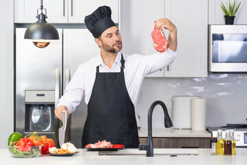 Handsome man cooking in kitchen. Mature man cooking with vegetables and meat in kitchen interior. Caucasian man in apron and chef hat cook tasty lunch in kitchen. Healthy food for dinner.