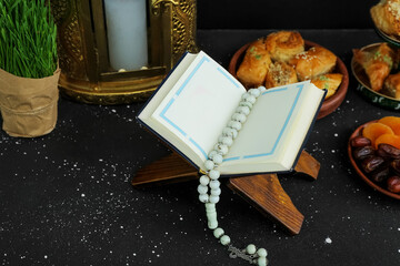 Obraz na płótnie Canvas Koran, tasbih and sweets on dark background. Islamic New Year celebration