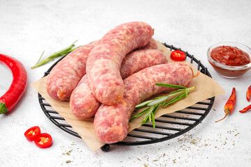 Grid with raw homemade sausages on light background