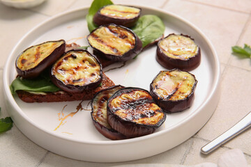 Toasts with delicious grilled eggplants on light background
