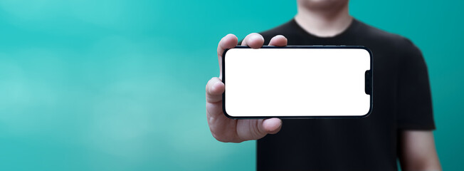 Fototapeta premium cell phone in hand with white screen held horizontally with blue background - easy modification