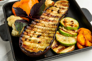Baking dish with grilled vegetables and basil, closeup