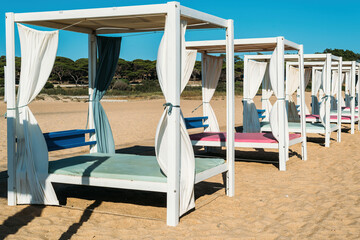 Fototapeta na wymiar Luxurious sunloungers on the beach at Quarteira, Algarve, Portugal