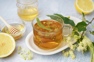 Glass cup of linden tea and bowl with honey on white background