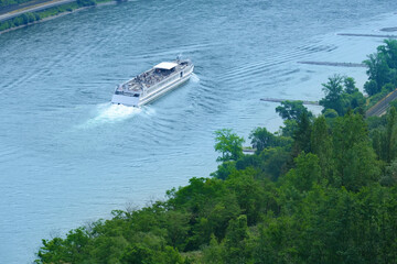 Ferry cruising, white tourist ship on river rhine in beautiful valley among luxurious vineyards...