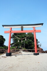 Fototapeta na wymiar 砂浜に立つ鳥居の菅原神社