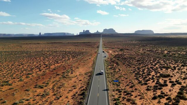Monument Valley, wide open endless dry desert area at the sunset. Top cinematic aerial view. Family car trip to the Utah Valley. Landmarks of USA. American landscape and wild nature